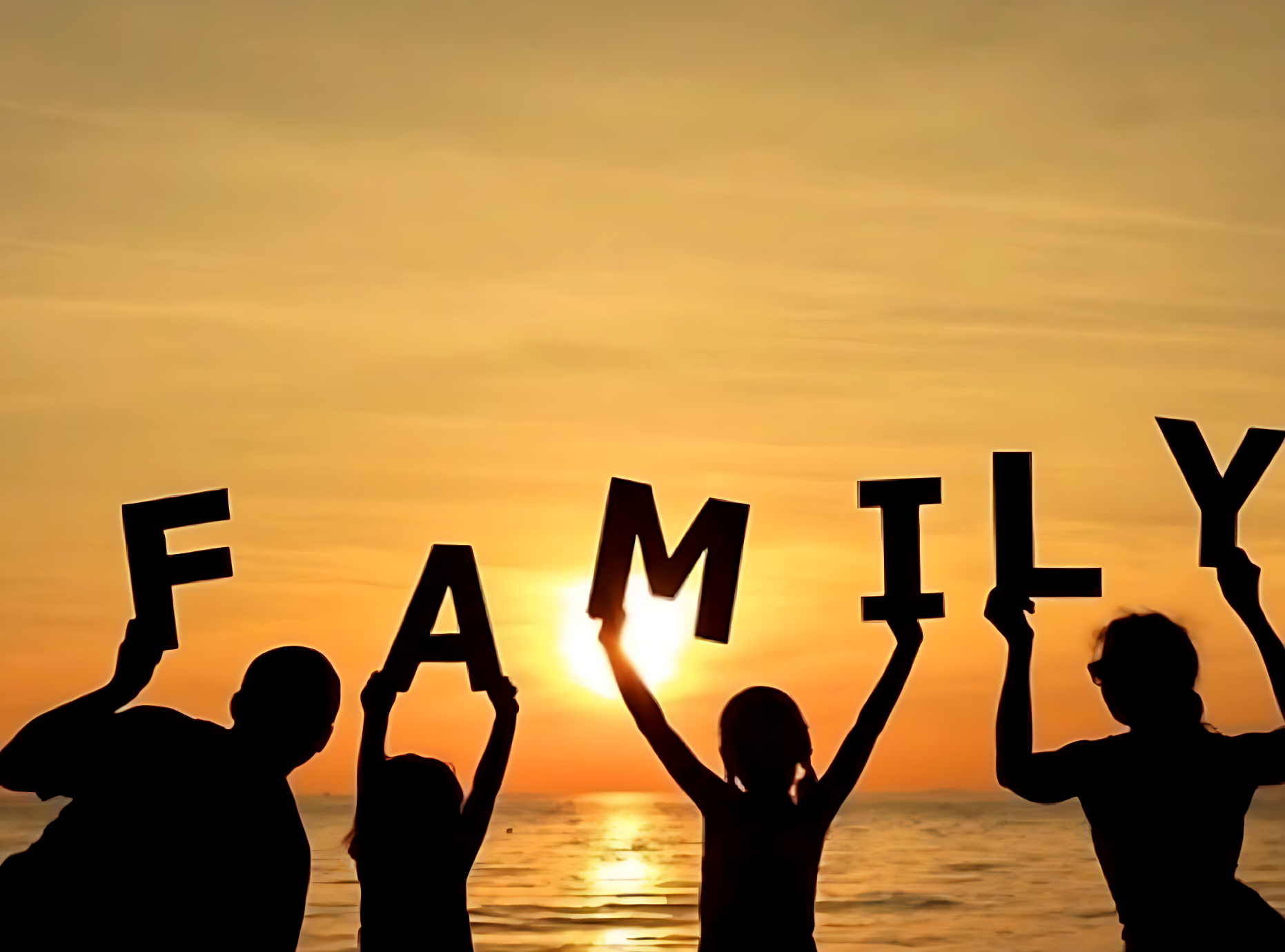 Family at sunset on beadnell beach Silhouette of a family holding letters spelling "FAMILY" against a sunset.